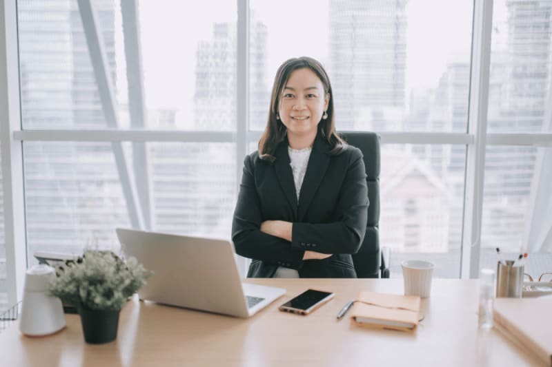 Smiling woman wearing a blazer in front of an office table