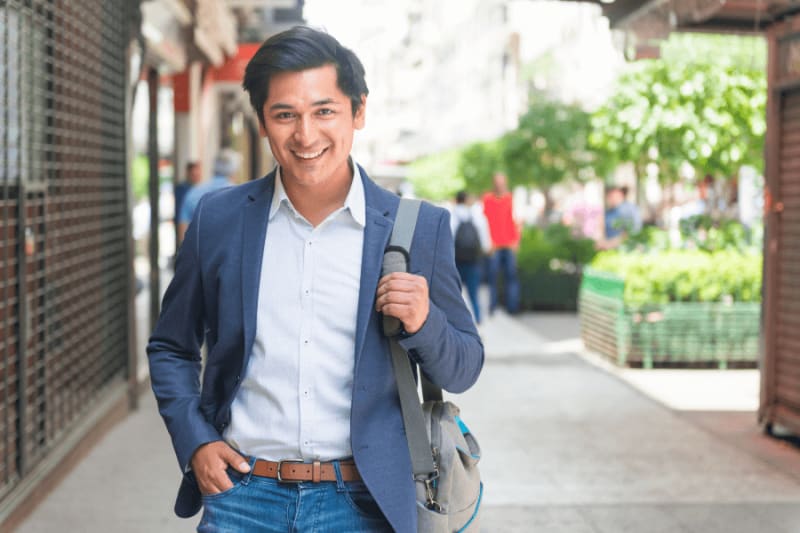 Smiling man wearing a suit and carrying a bag