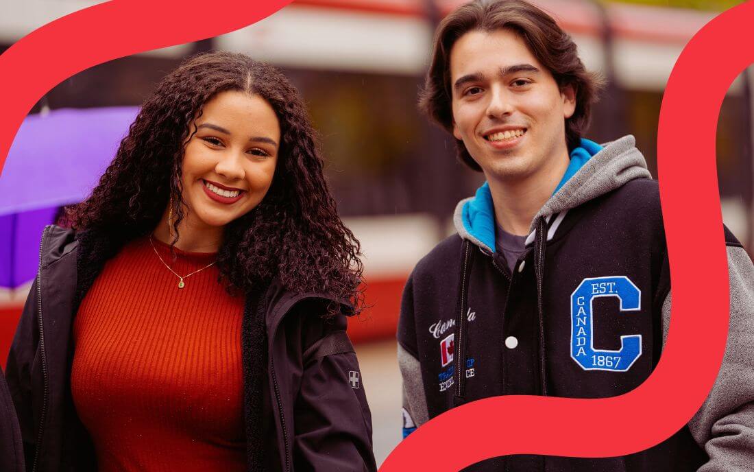 two students looking at camera and smiling