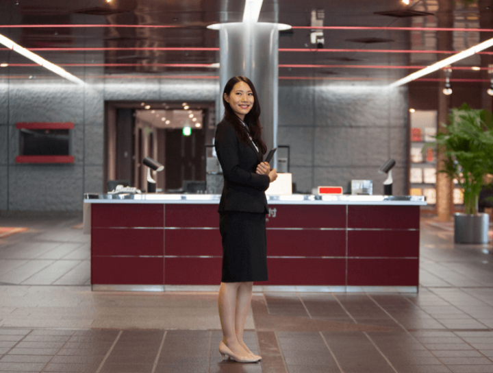 Woman dressed professionally standing at the center of an office