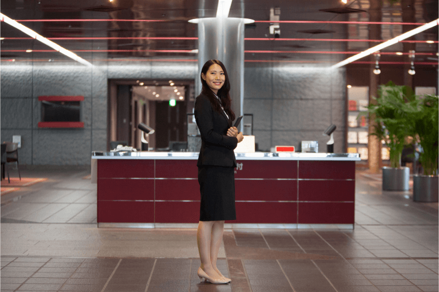 Woman dressed professionally standing at the center of an office