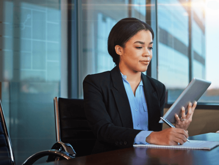 Image of a professional woman reading from a digital tablet