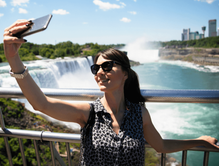 Woman taking a selfie with Niagara Falls in the background