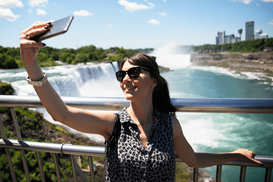 Woman taking a selfie with Niagara Falls in the background