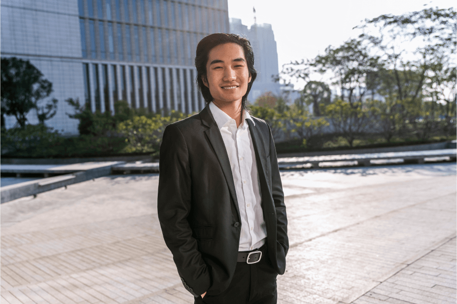 Image of a young adult wearing a suit and smiling confidently